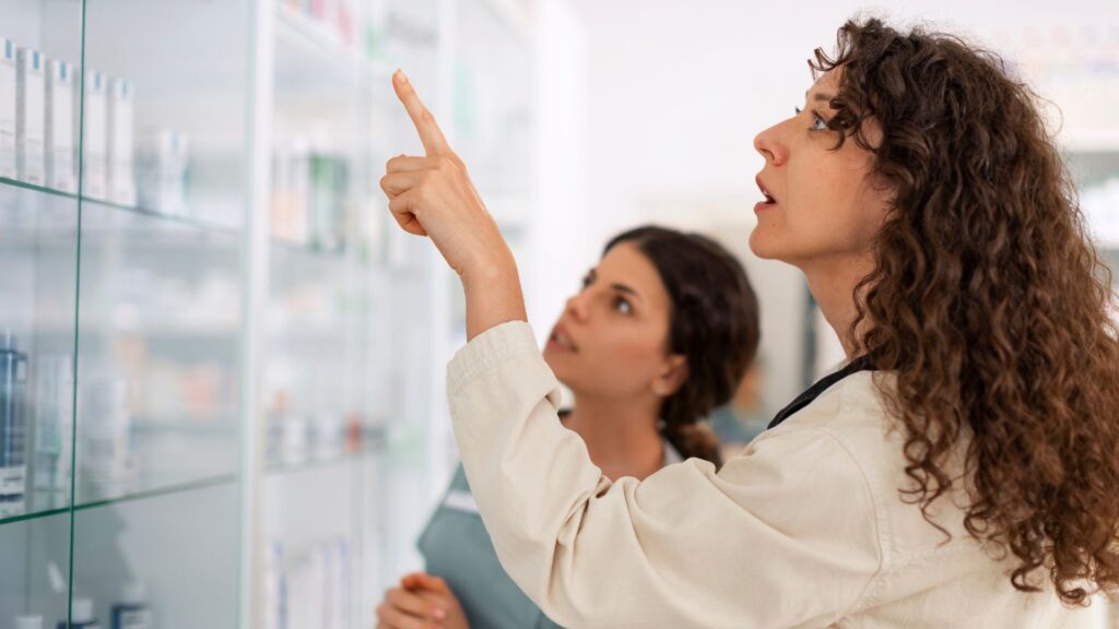 Profissionais avaliando produtos farmacêuticos em prateleira durante inspeção de controle de qualidade com suporte da Labpharma