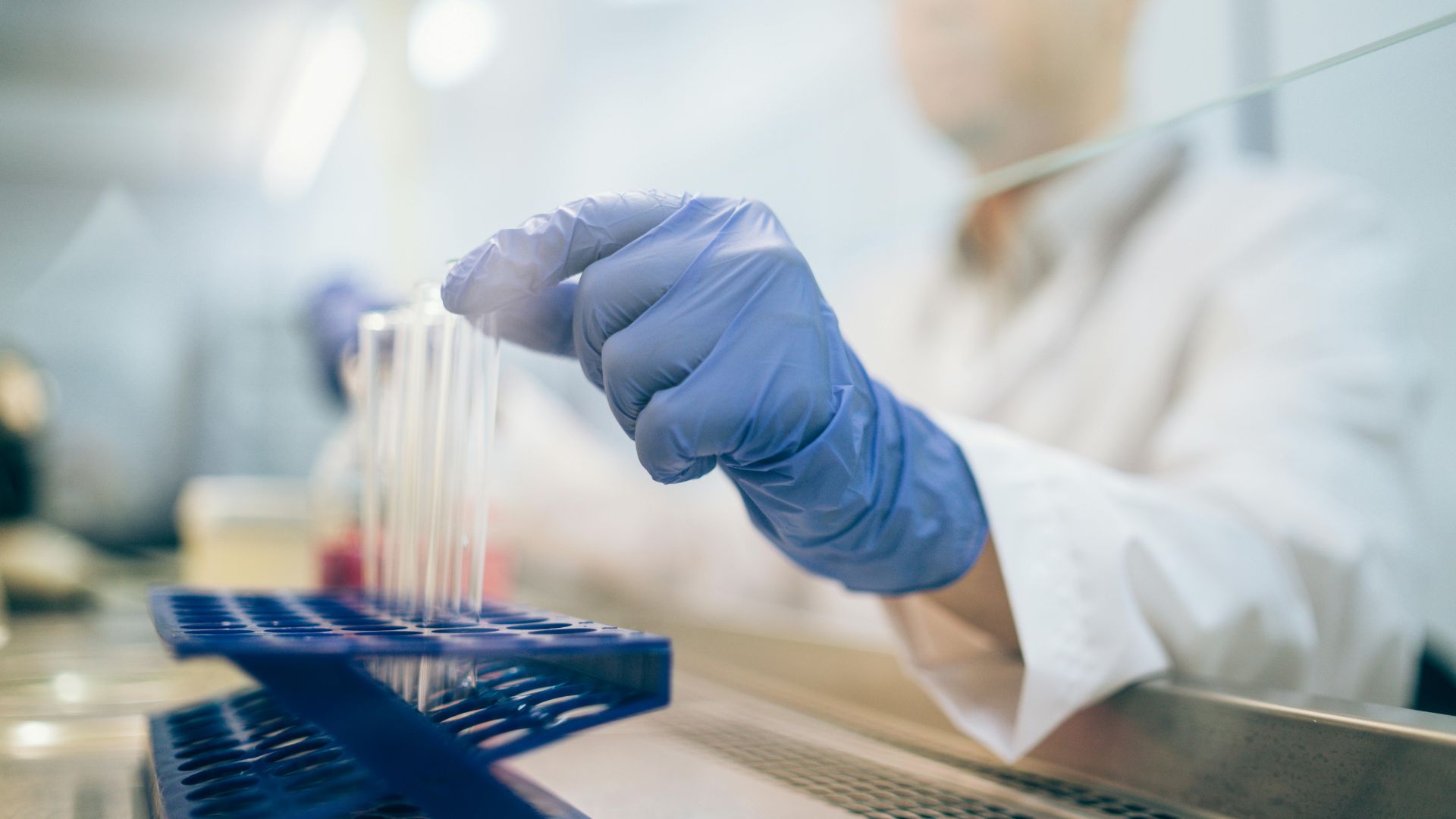 Profissional realizando análises farmacêuticas em laboratório com tubos de ensaio, controle de qualidade terceirizado pela Labpharma